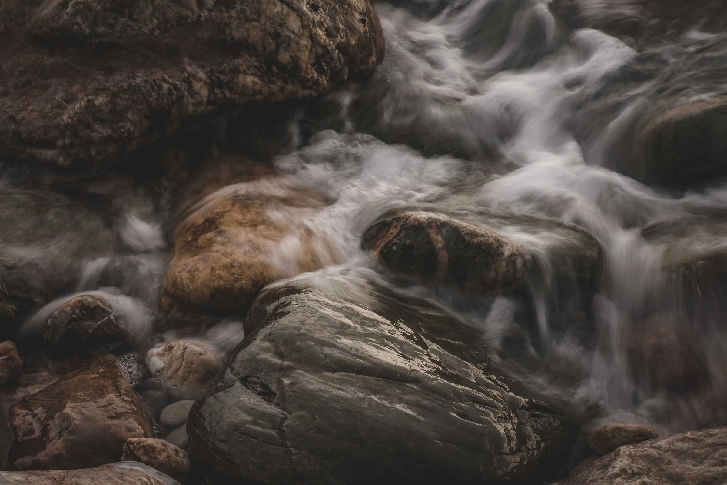 A clear stream flowing steadily over smooth stones